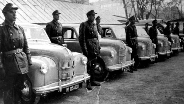 Historisches Foto: Gendarmen neben Dienstautos 